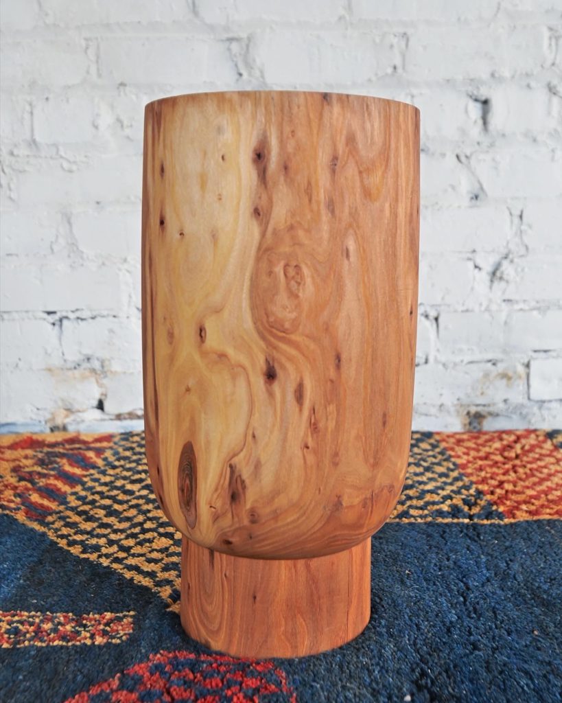 wooden sculpture table on gabbeh rug